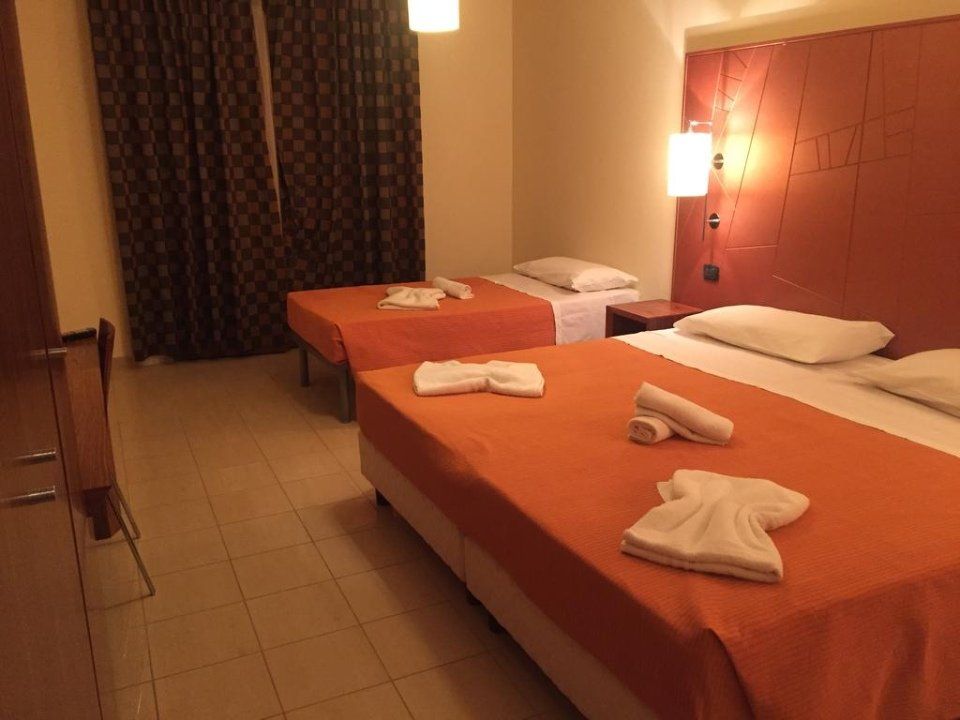 Una camera d'albergo con due letti e asciugamani sopra