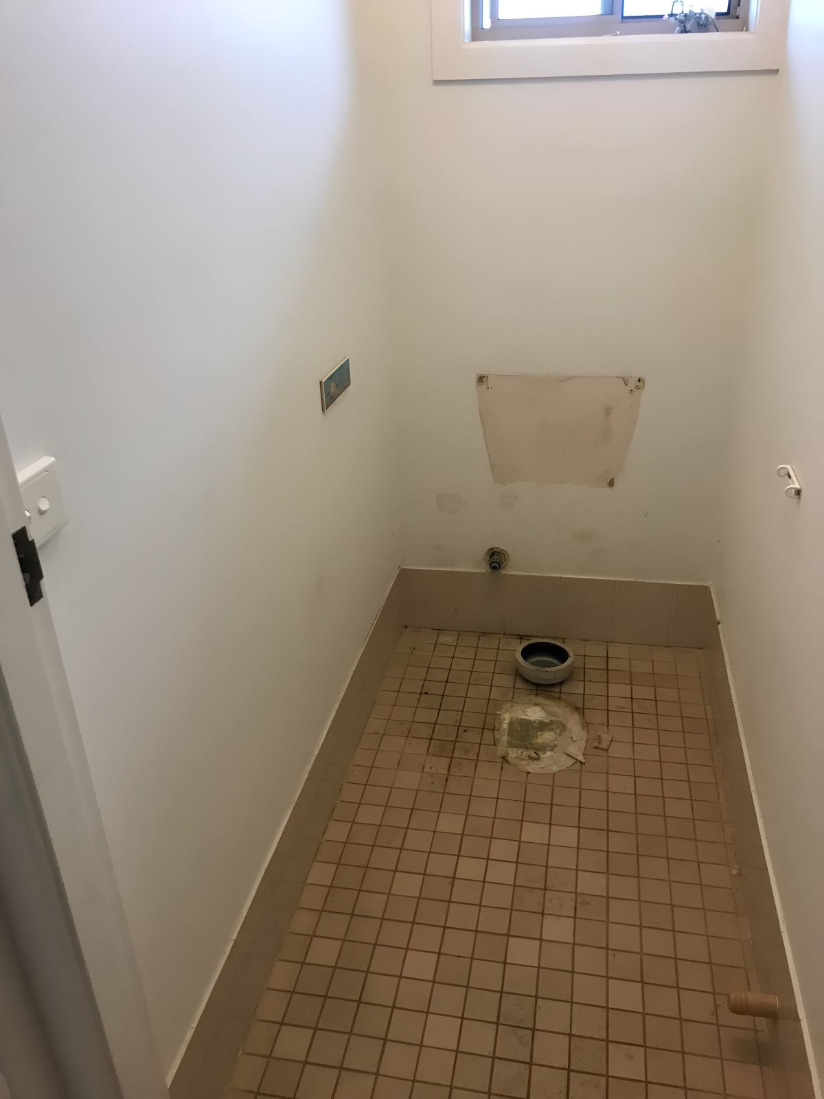 A Bathroom With A Tiled Floor And White Walls Under Renovation — Coffs Coast Designer Bathrooms in Bellingen, NSW