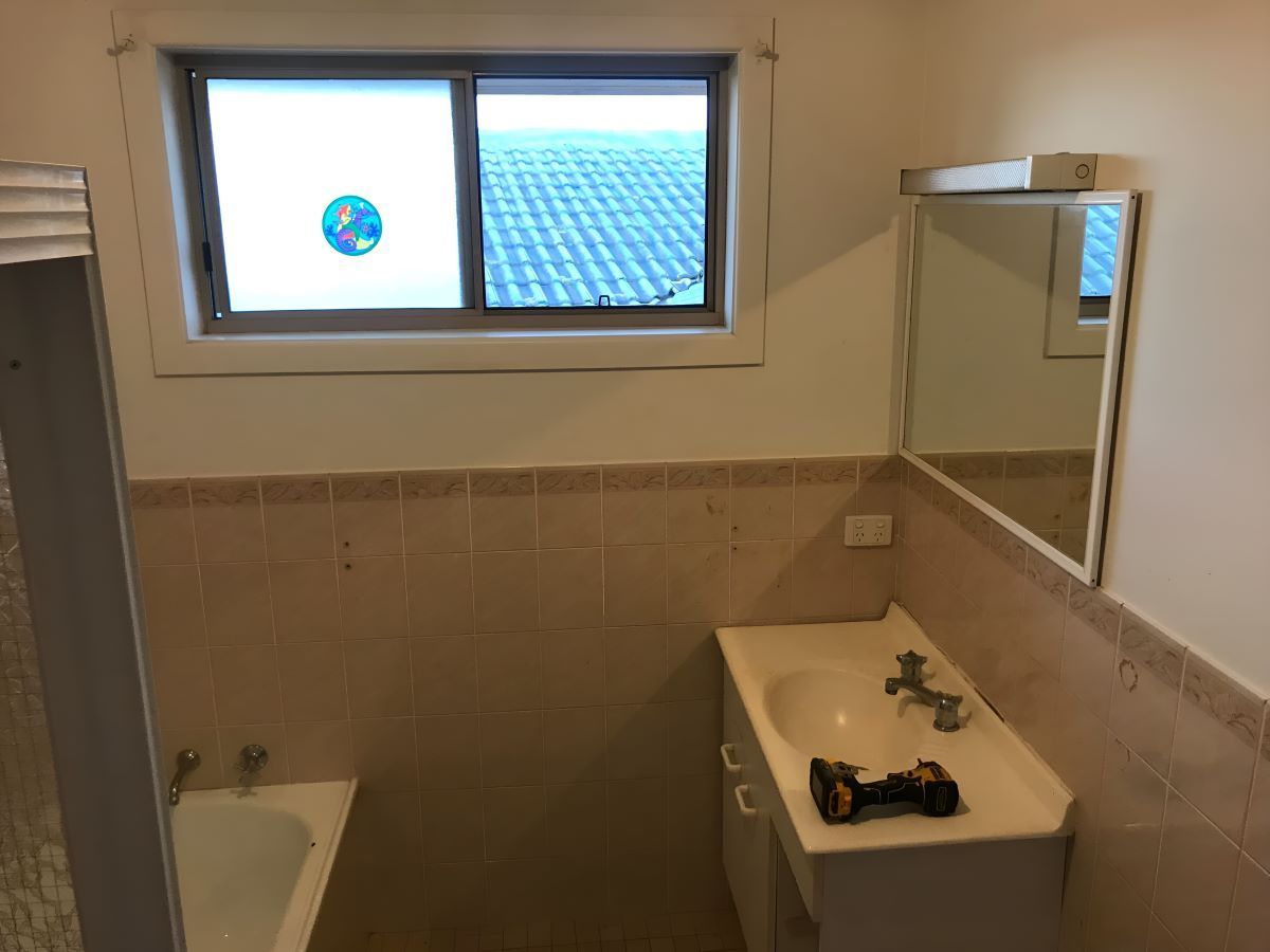 A Bathroom With A Sink, Bathtub, Mirror, And Window — Coffs Coast Designer Bathrooms in Urunga, NSW