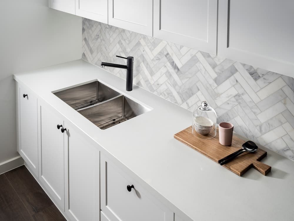 Kitchen With A Marble Backsplash And White Cabinets — Coffs Coast Designer Bathrooms in Toormina, NSW