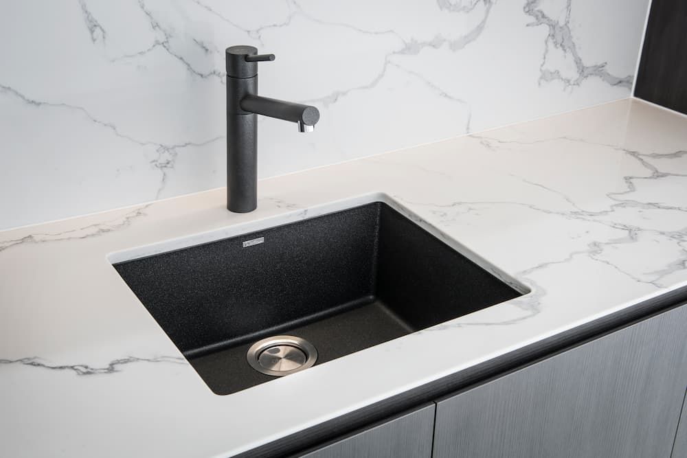 Kitchen Sink With A Black Faucet And Marble Counter Top — Coffs Coast Designer Bathrooms in Toormina, NSW