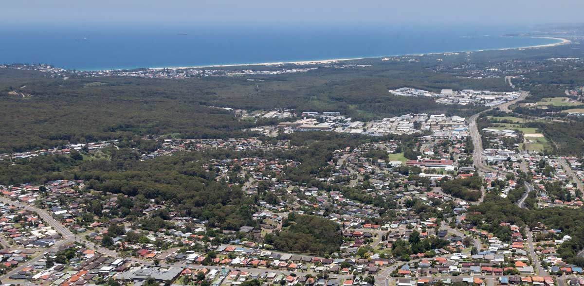 An Aerial View Of A City Surrounded By Trees And A Body Of Water — Coffs Coast Designer Bathrooms in Toormina, NSW