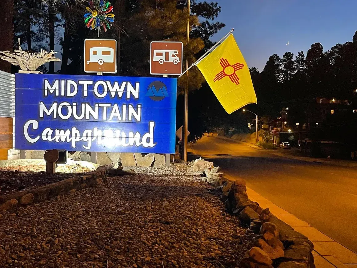 A blue sign that says midtown mountain campground on it