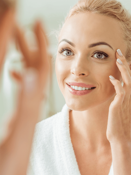 Woman looking at reflection for fine lines and wrinkles