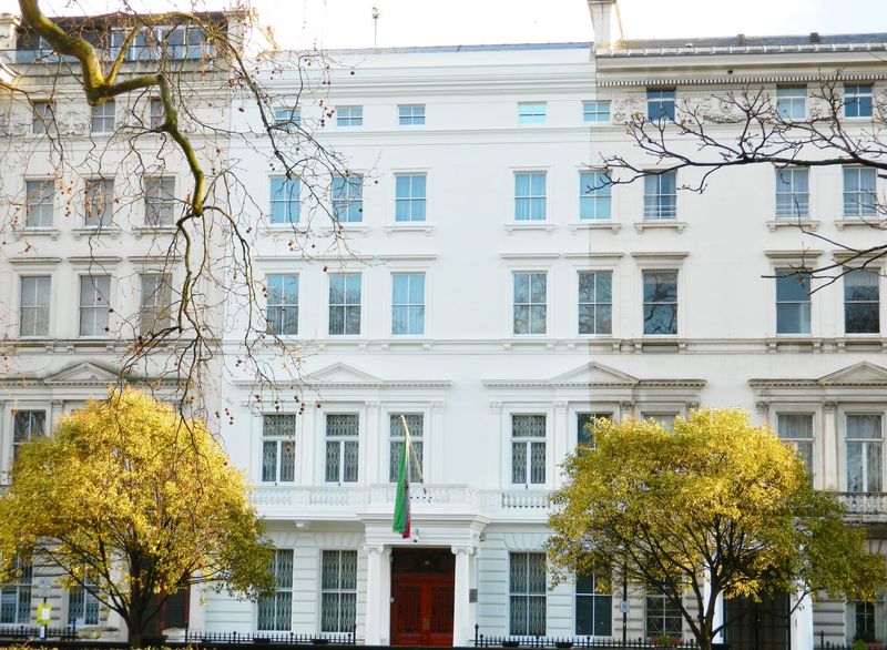 A white stucco townhouse facade on a London square