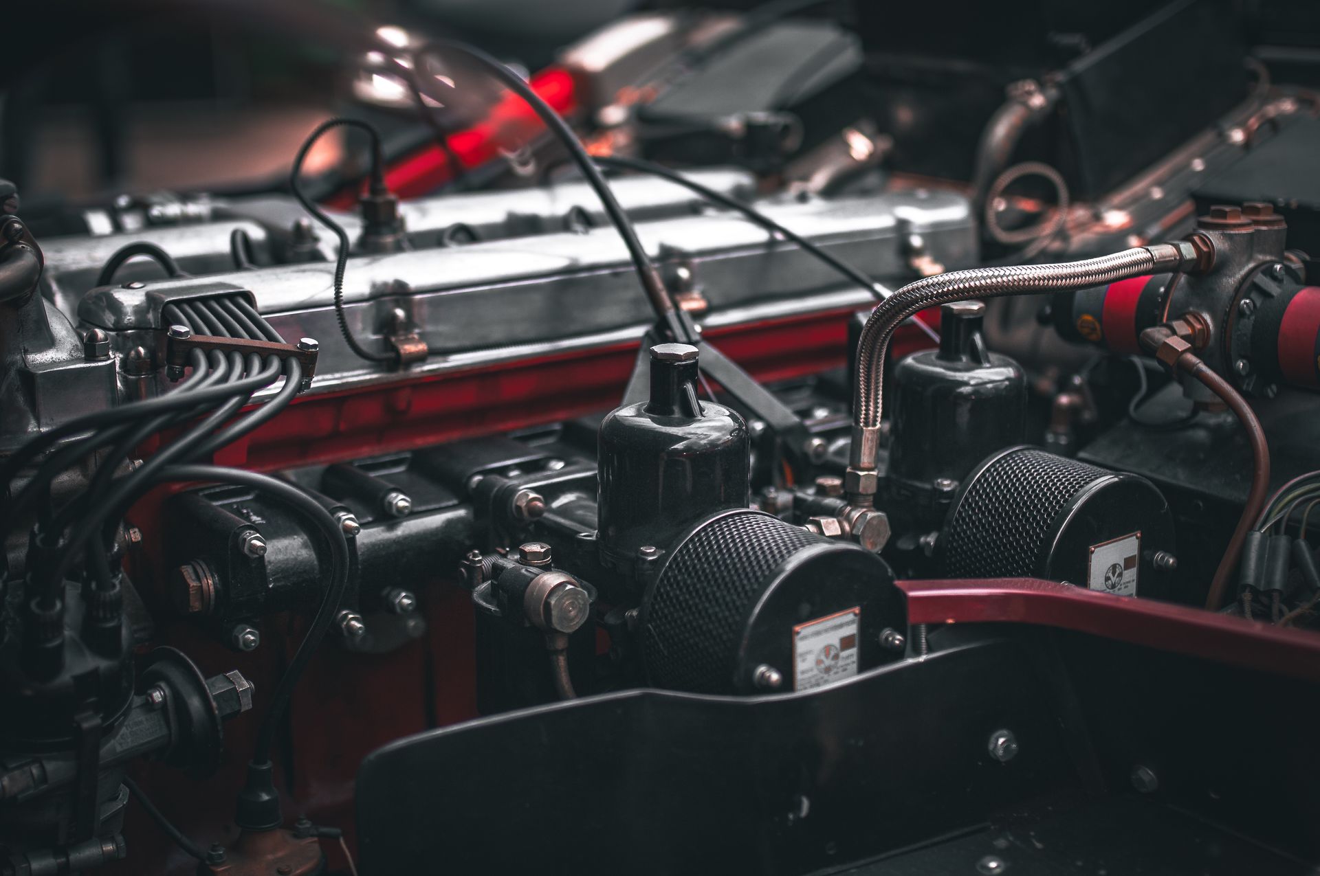 A close up of a car engine with a lot of wires coming out of it.