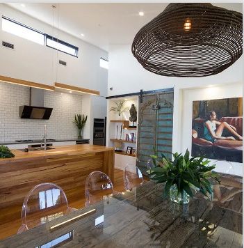 A kitchen with a table and chairs and a painting on the wall | House Building Services | Clifton Springs