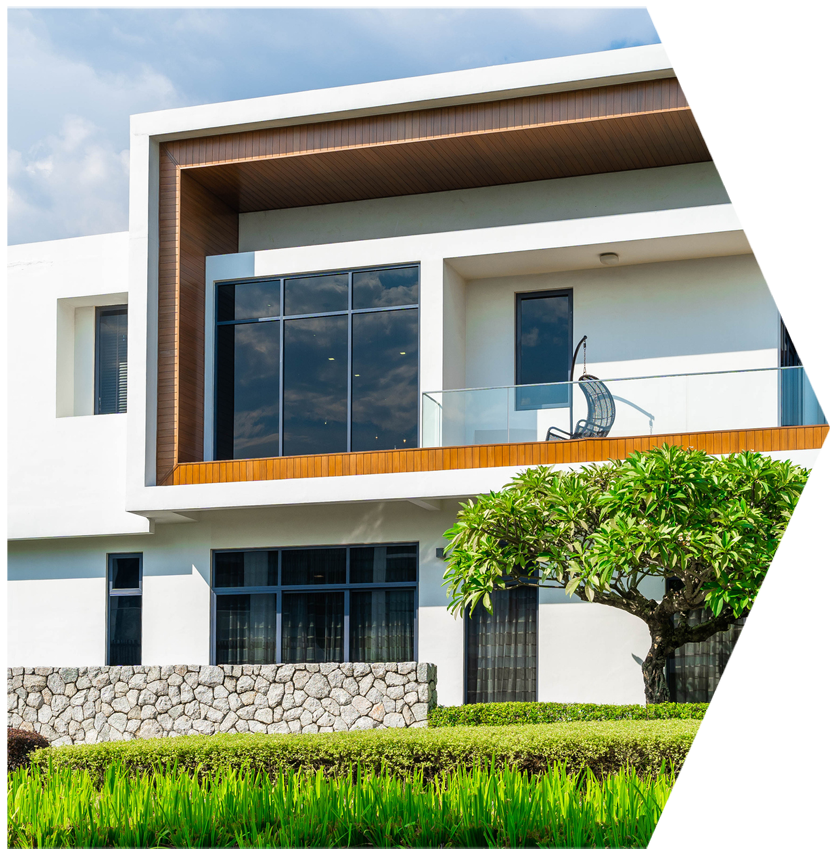 A large white house with a balcony and a tree in front of it | House Building Services | Clifton Springs