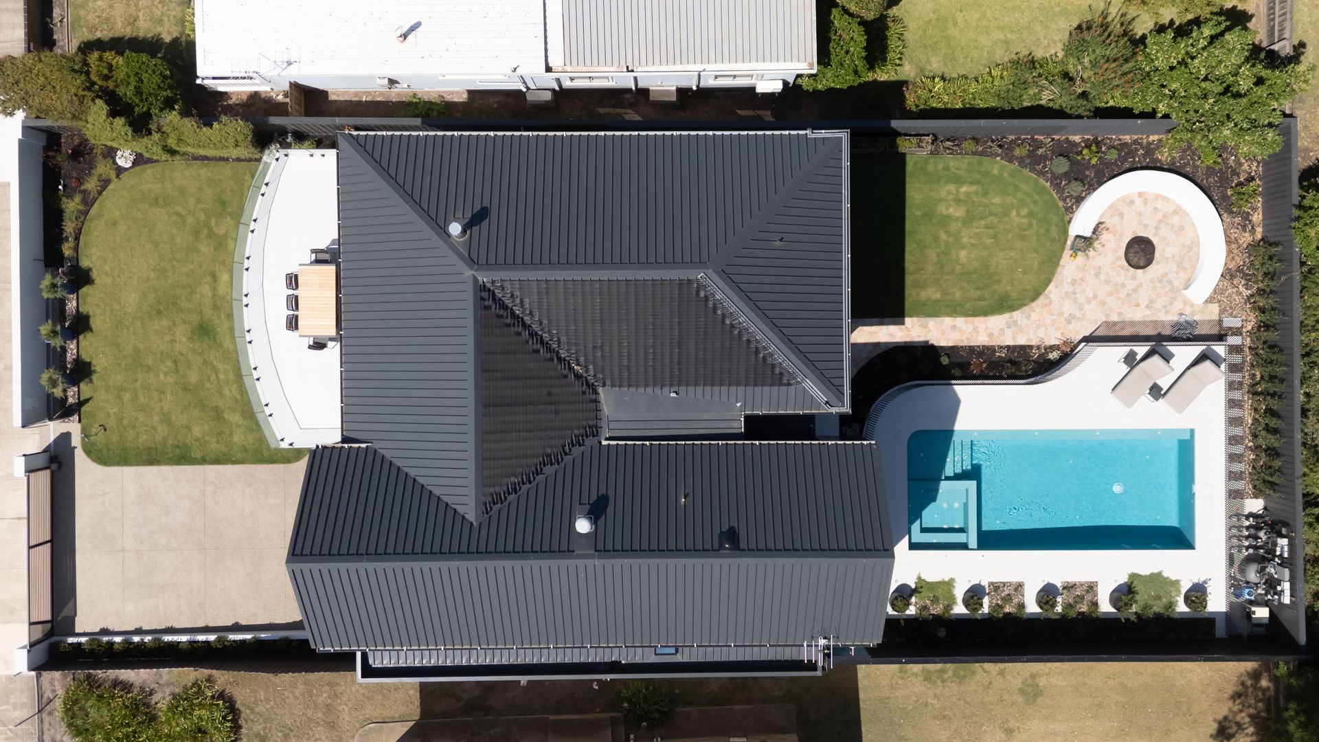 An aerial view of a large house with a large deck surrounded by trees.