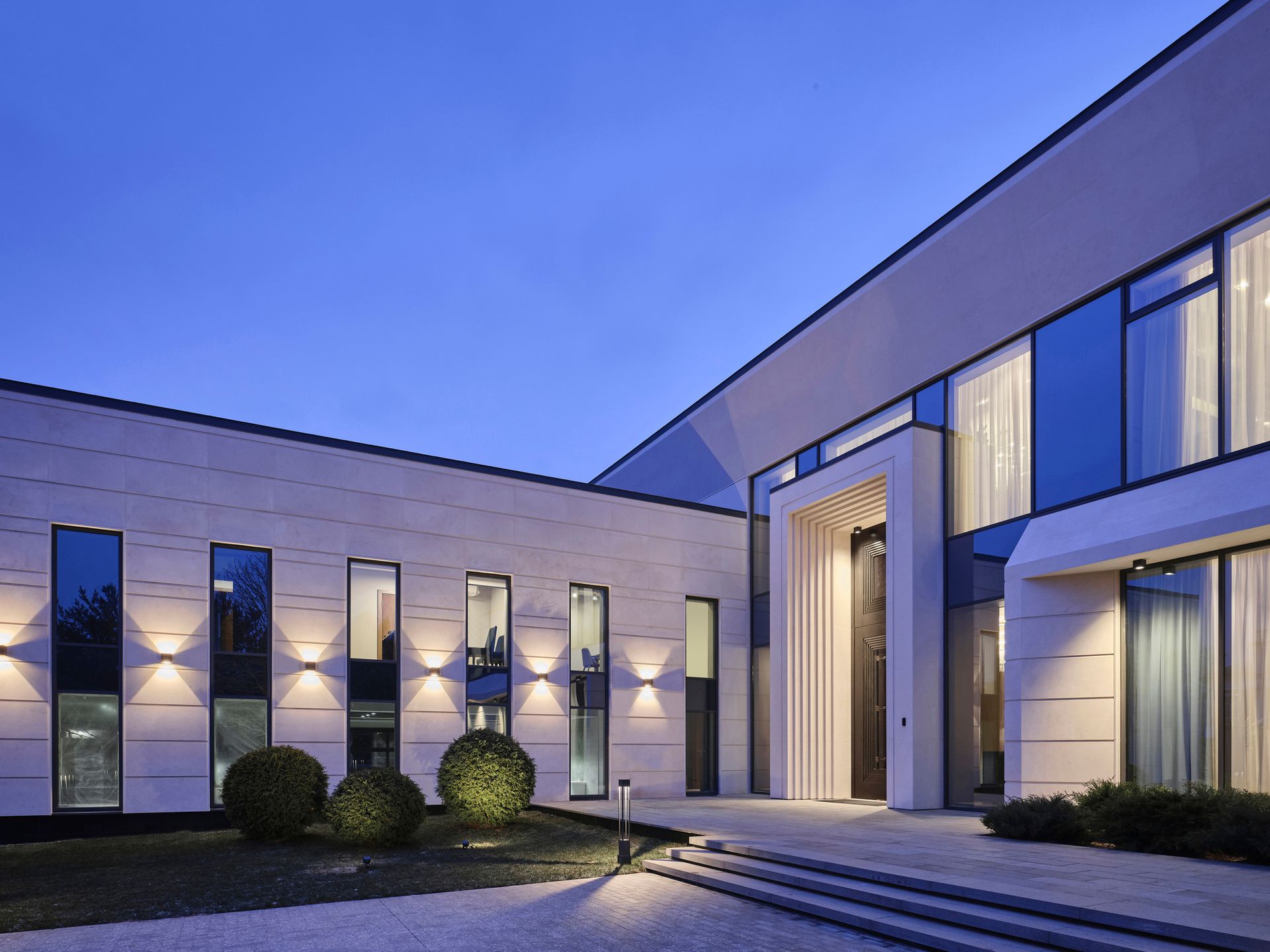 A large building with a lot of windows is lit up at night | Building Services | Coastyle