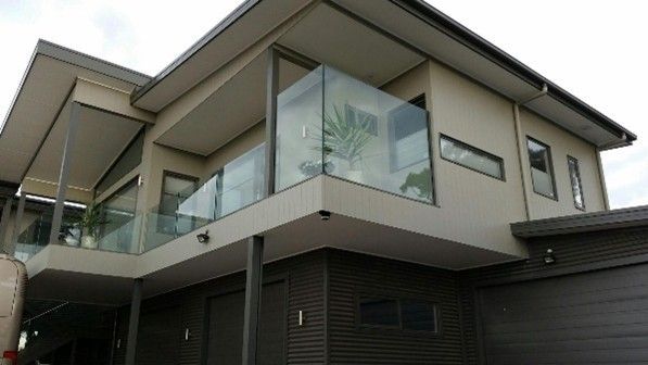 View of a sleek two-storey home with a balcony, showcasing a custom home renovation. View of a sleek two-storey home with a balcony, showcasing a custom home renovation.