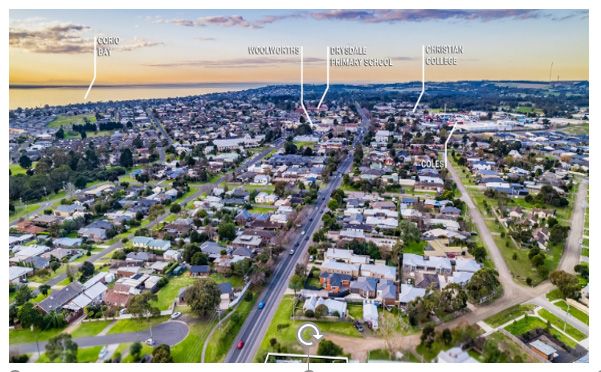 An aerial view of a residential area with a city in the background.