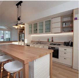A kitchen with white cabinets and a wooden table | House Building Services | Clifton Springs