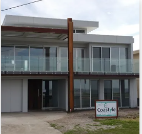 A large house with a sign that says coastyle on it | House Building Services | Clifton Springs