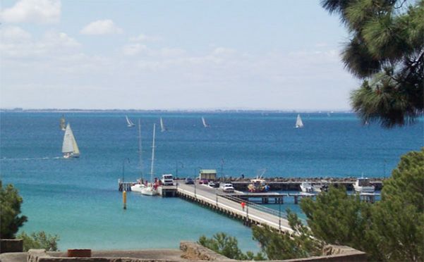 A view of a pier with boats in the ocean
