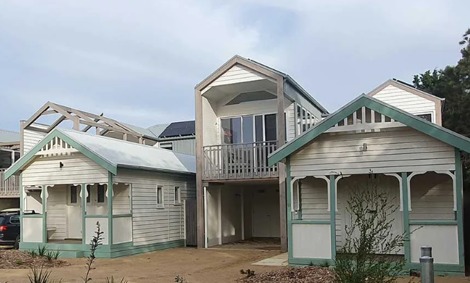 A group of white houses with green roofs are sitting next to each other | House Building Services | Clifton Springs