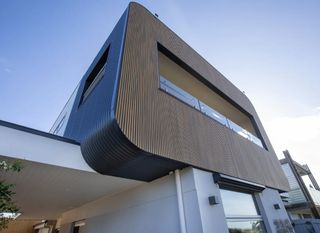 A modern house with a balcony and a blue sky in the background | House Building Services
