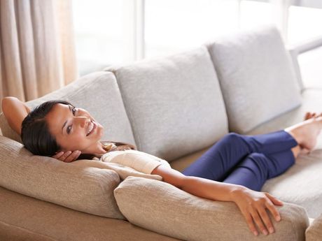 Woman relaxing comfortably on a couch in a bright living room