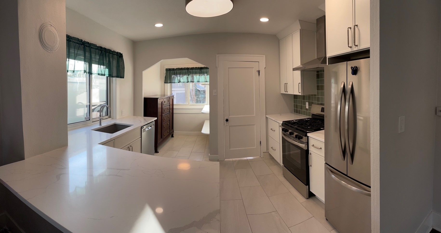 Kitchen with white cabinets, stainless steel appliances, and a quartz countertop.