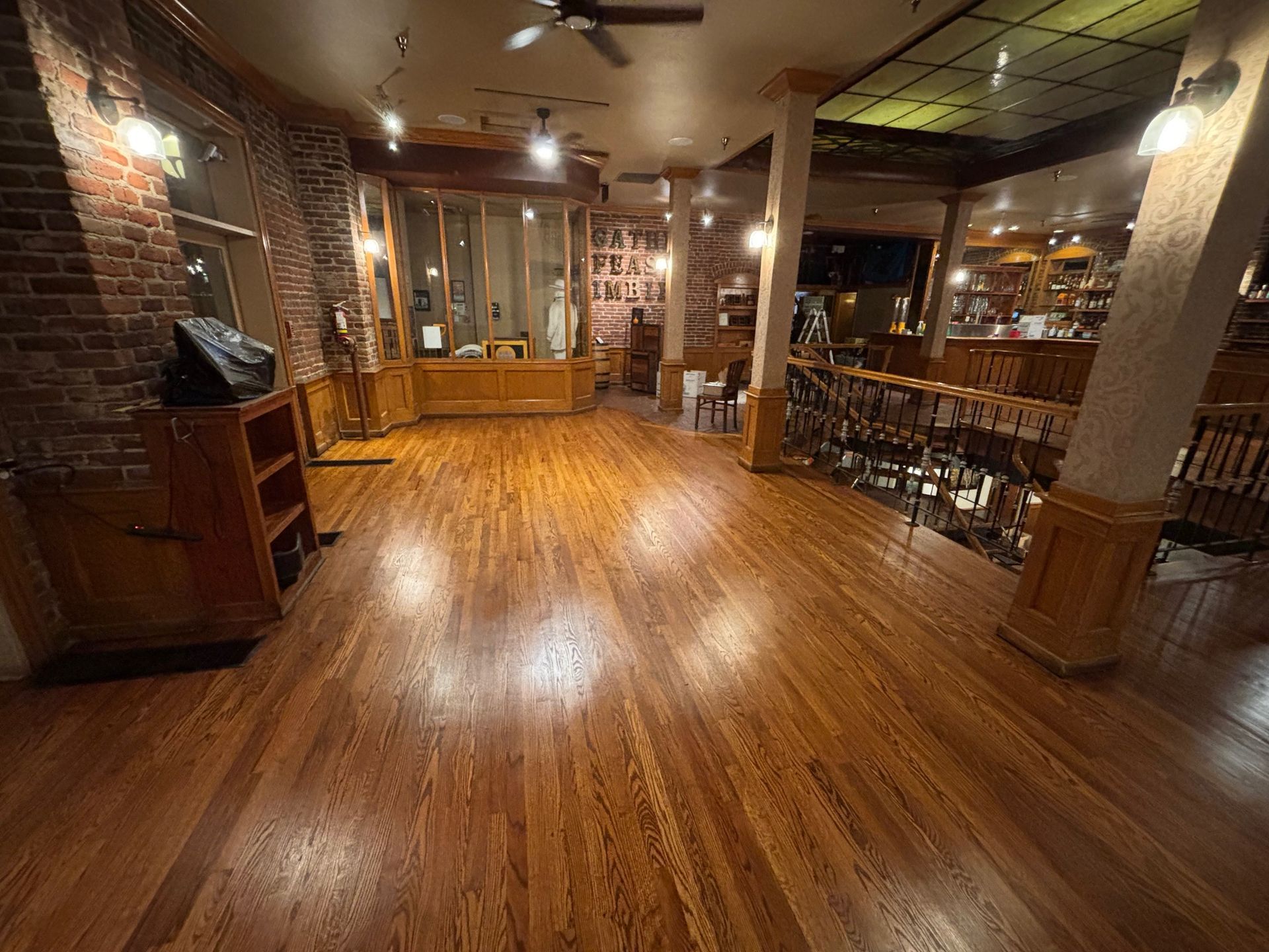 Well-lit interior with hardwood floors, exposed brick walls, and a bar area; Restaurant and event space.