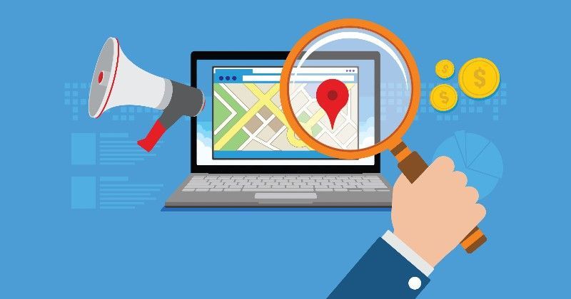 Laptop showing map with red location marker, being magnified, megaphone, and coins.