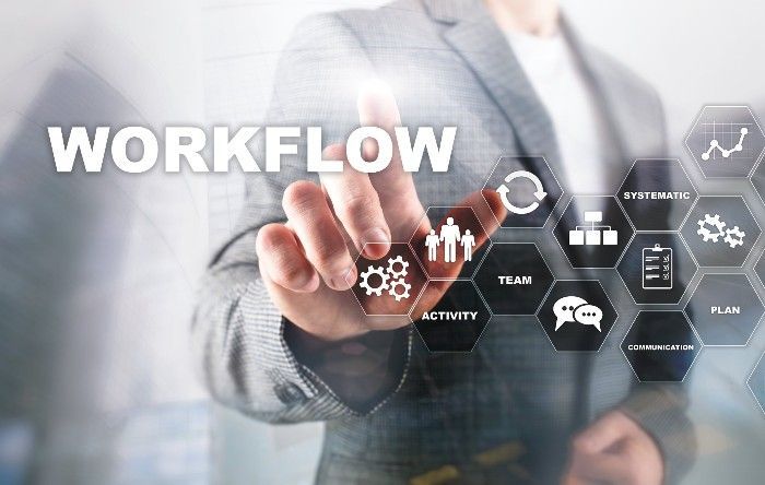 Person touching digital workflow graphic with icons representing team, communication, and planning.