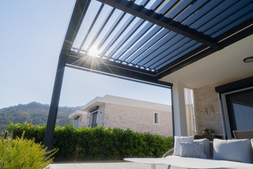 A Patio With a Pergola and a Couch Underneath It — Lakecrest Projects in Belmont North, NSW