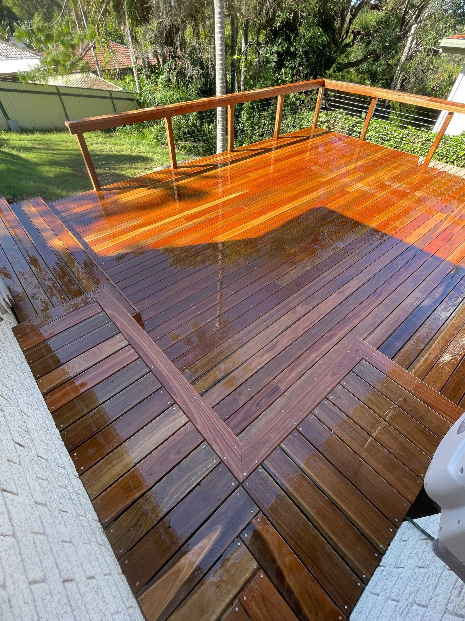 Wooden Deck With Wet, Glossy Planks and a Railing — Lakecrest Projects in Belmont North, NSW