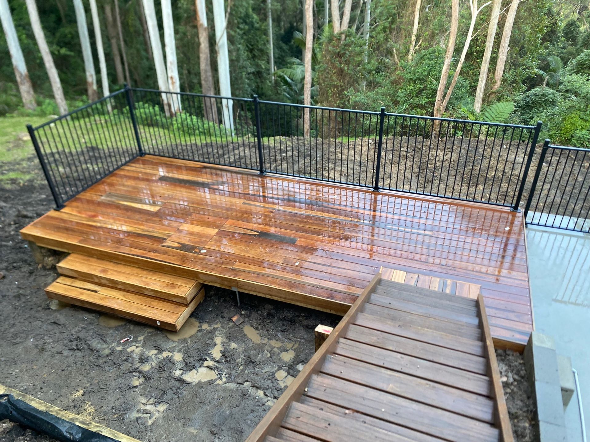 Wooden Deck With Black Railing in a Wooded Backyard — Lakecrest Projects in Belmont North, NSW