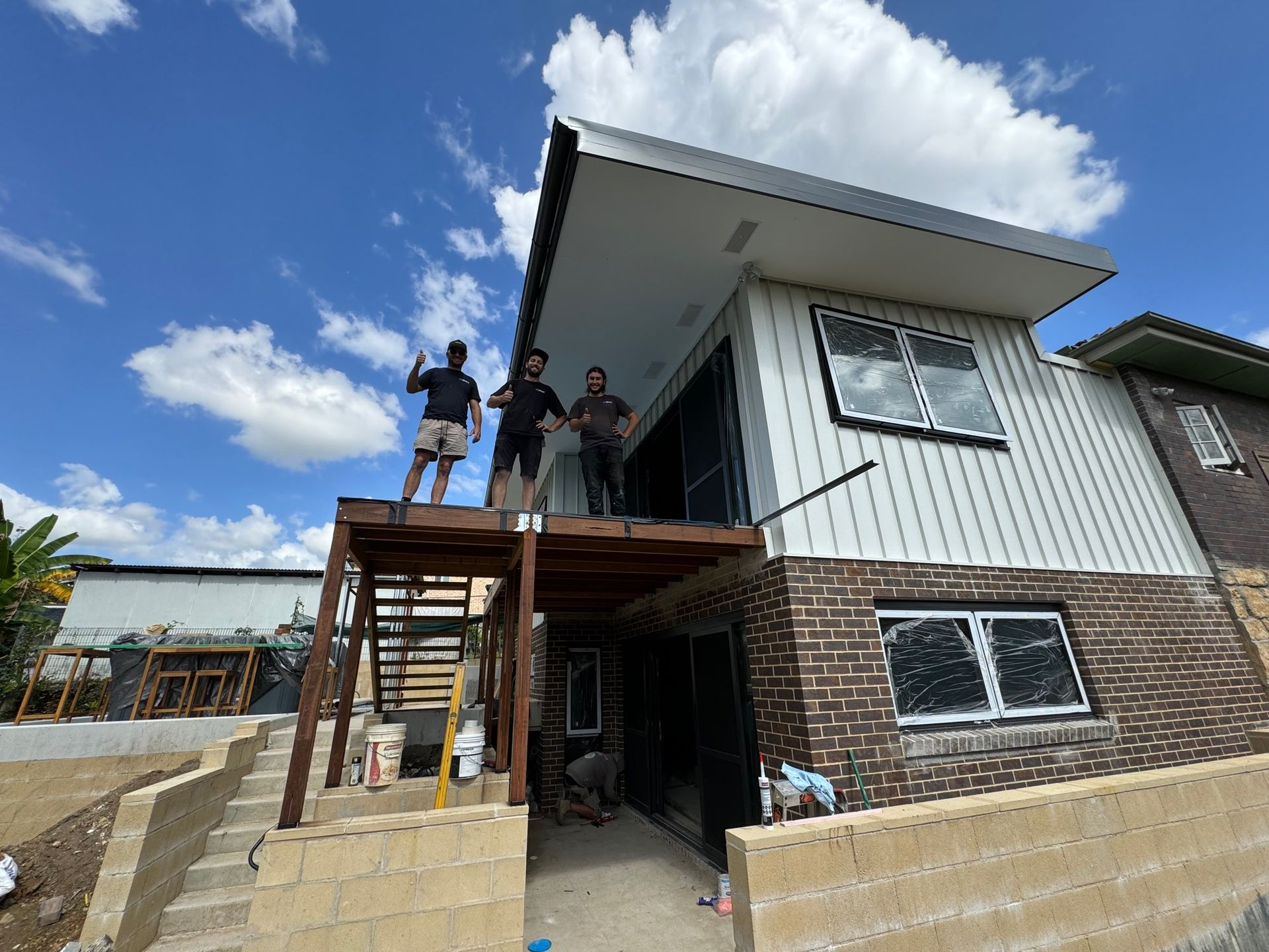 People Standing on a Wooden Scaffold Beside a Two-story House — Lakecrest Projects in Belmont North, NSW