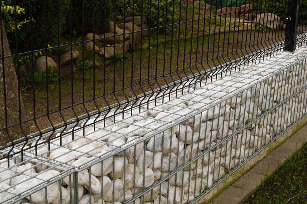 A Stone Wall With a Metal Fence Surrounding It — Lakecrest Projects in Hunter Valley, NSW