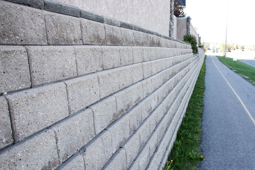A Brick Wall is Along the Side of a Road — Lakecrest Projects in Belmont North, NSW