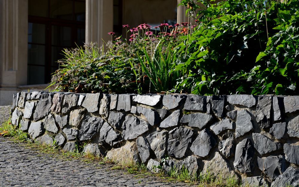 A Stone Wall With Plants Growing on It in Front of a House — Lakecrest Projects in Hunter Valley, NSW