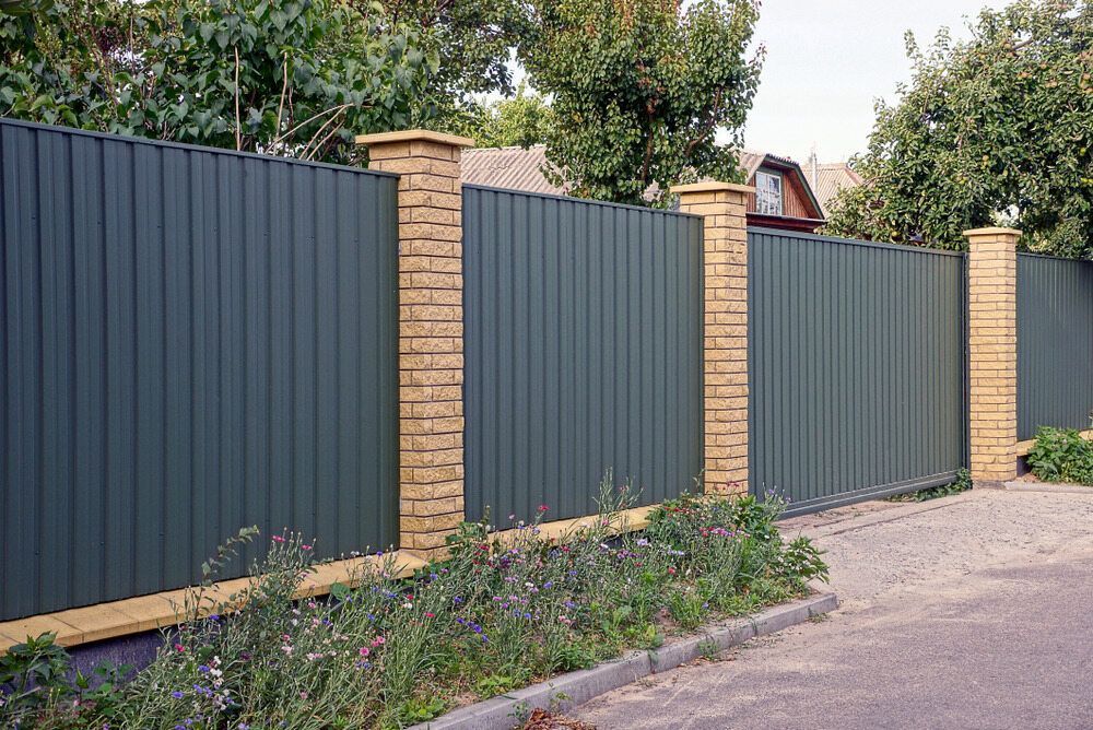 A Green Fence With Brick Pillars Along the Side of a Road — Lakecrest Projects in Hunter Valley, NSW