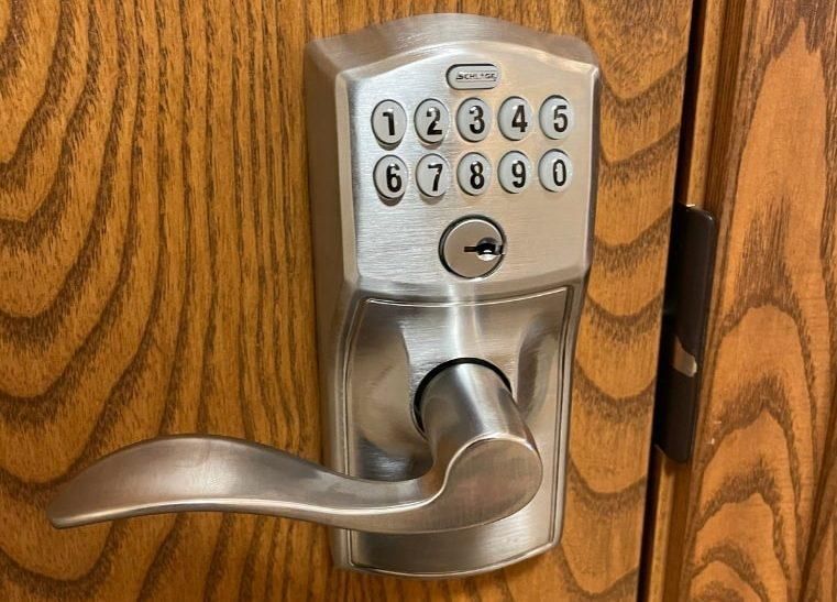 Woman using her fingerprint to unlock a door.