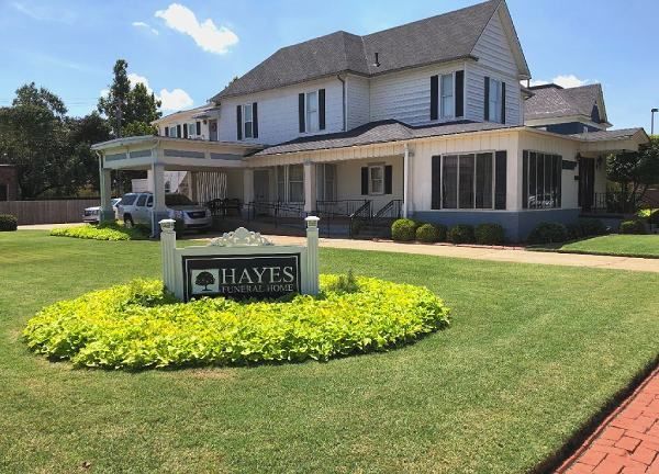 Hayes Funeral Home with a sign in front of a large white building.