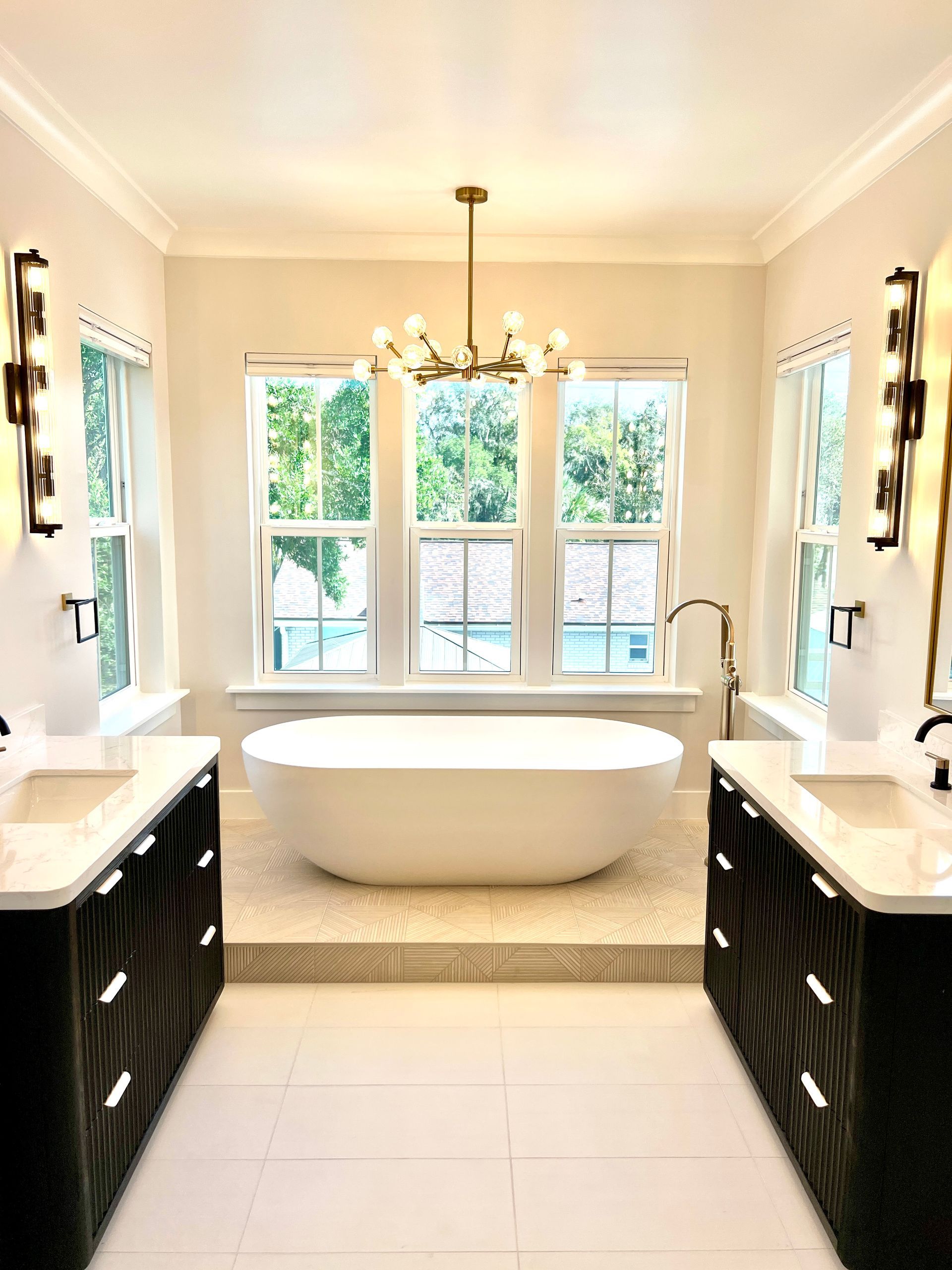 Modern white bathroom with bathtub, toilet, and vanity. Gray floor and neutral walls.