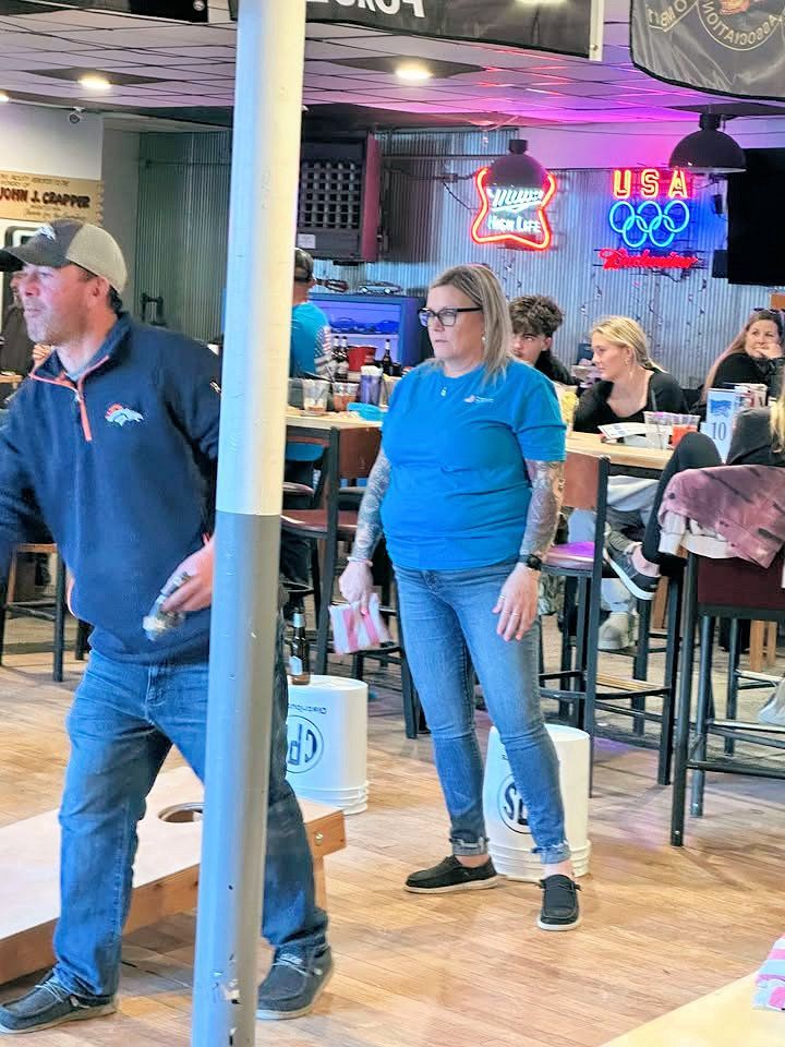 A man and a woman are standing in a restaurant.