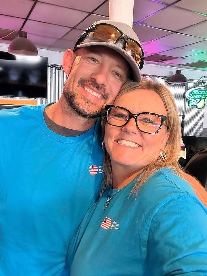A man and a woman are posing for a picture together in a restaurant.