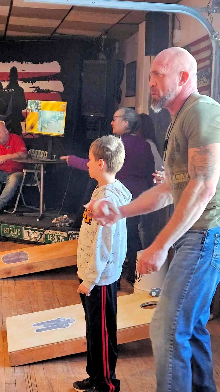 A man and a boy are standing next to each other in a room.