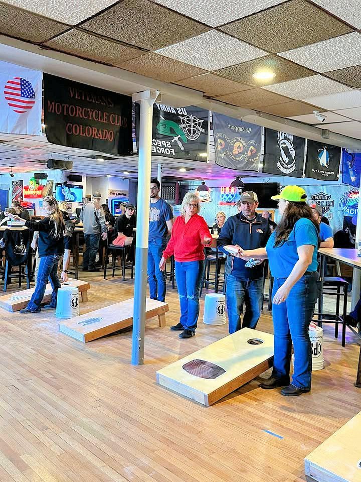 A group of people are playing cornhole in a restaurant.