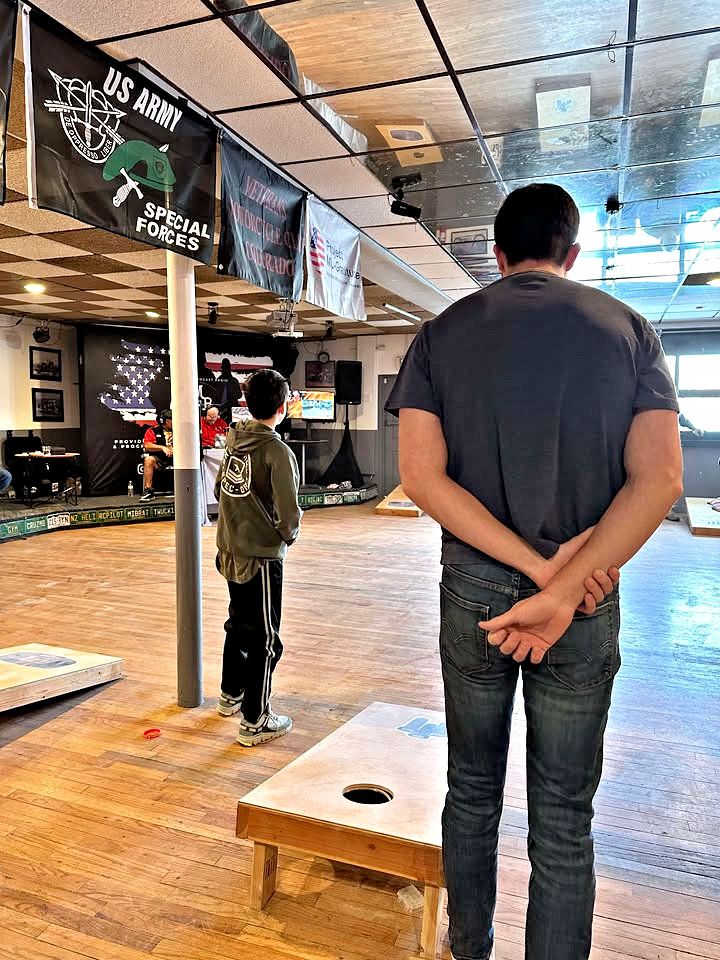 A man is standing in a room with his hands behind his back.