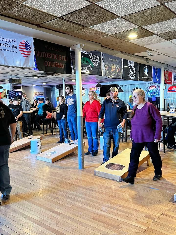 A group of people are playing cornhole in a restaurant.
