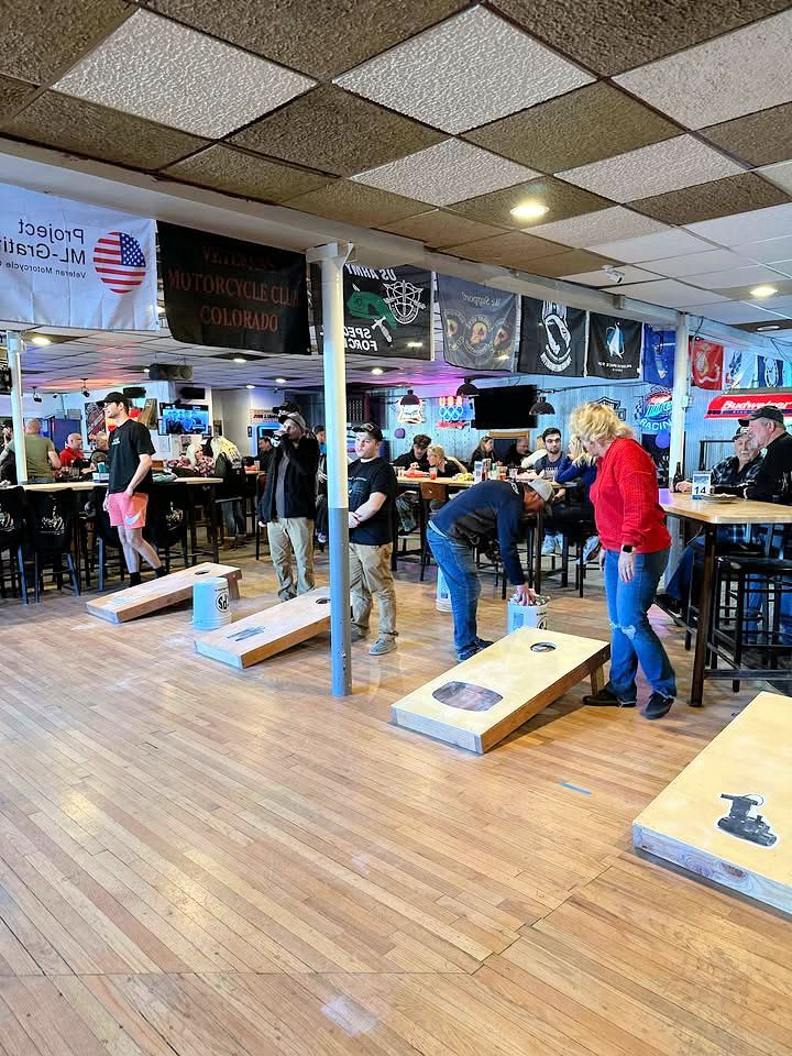 A group of people are playing cornhole in a restaurant.
