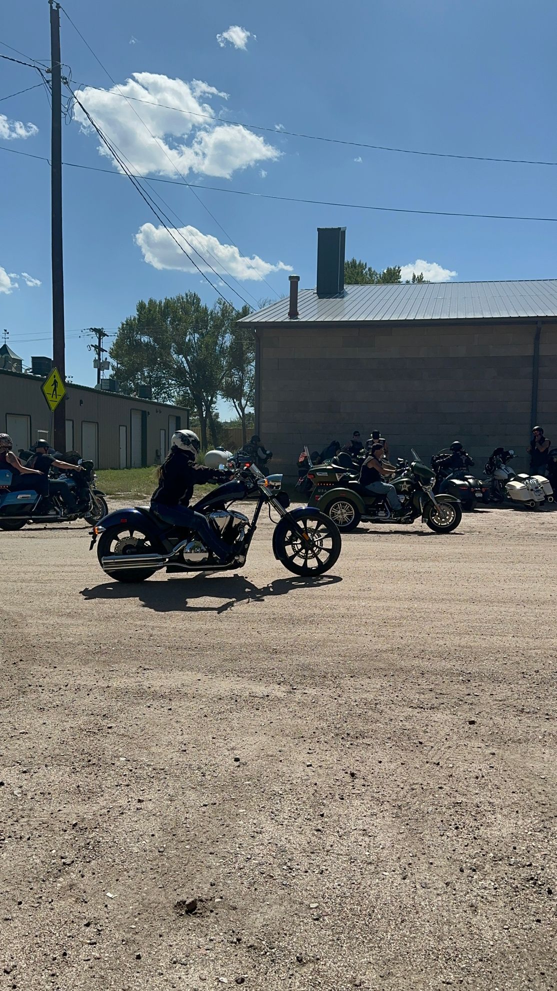 A group of people are riding motorcycles down a dirt road.