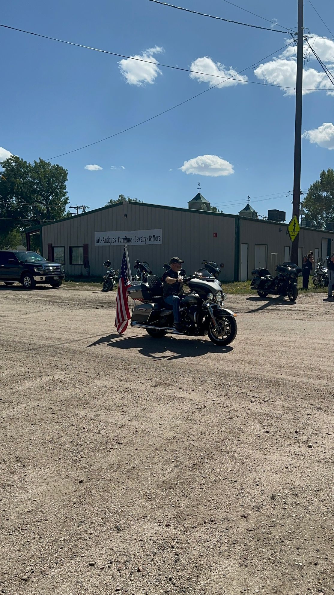 A group of people are riding motorcycles down a dirt road.