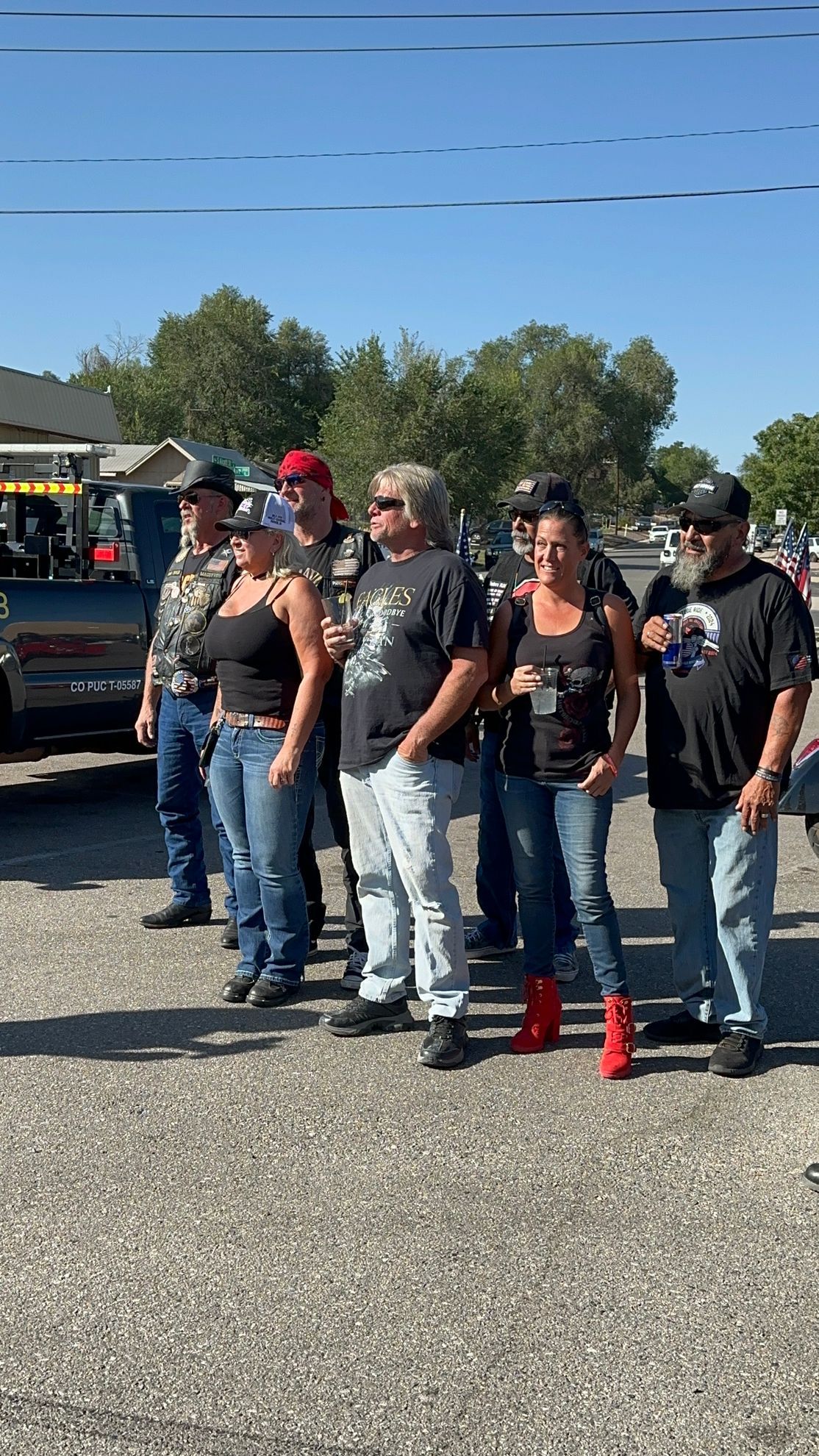 A group of people are standing next to each other in a parking lot.
