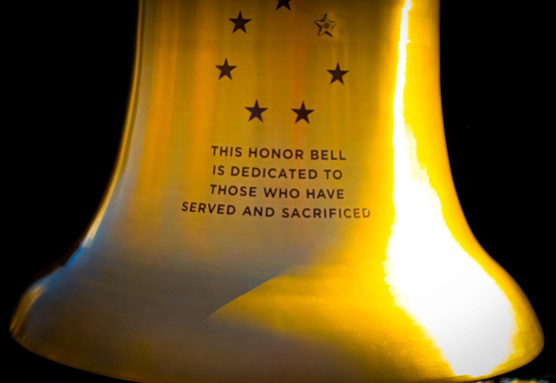 A close up of a bell that says this honor bell is dedicated to those who have served and sacrificed