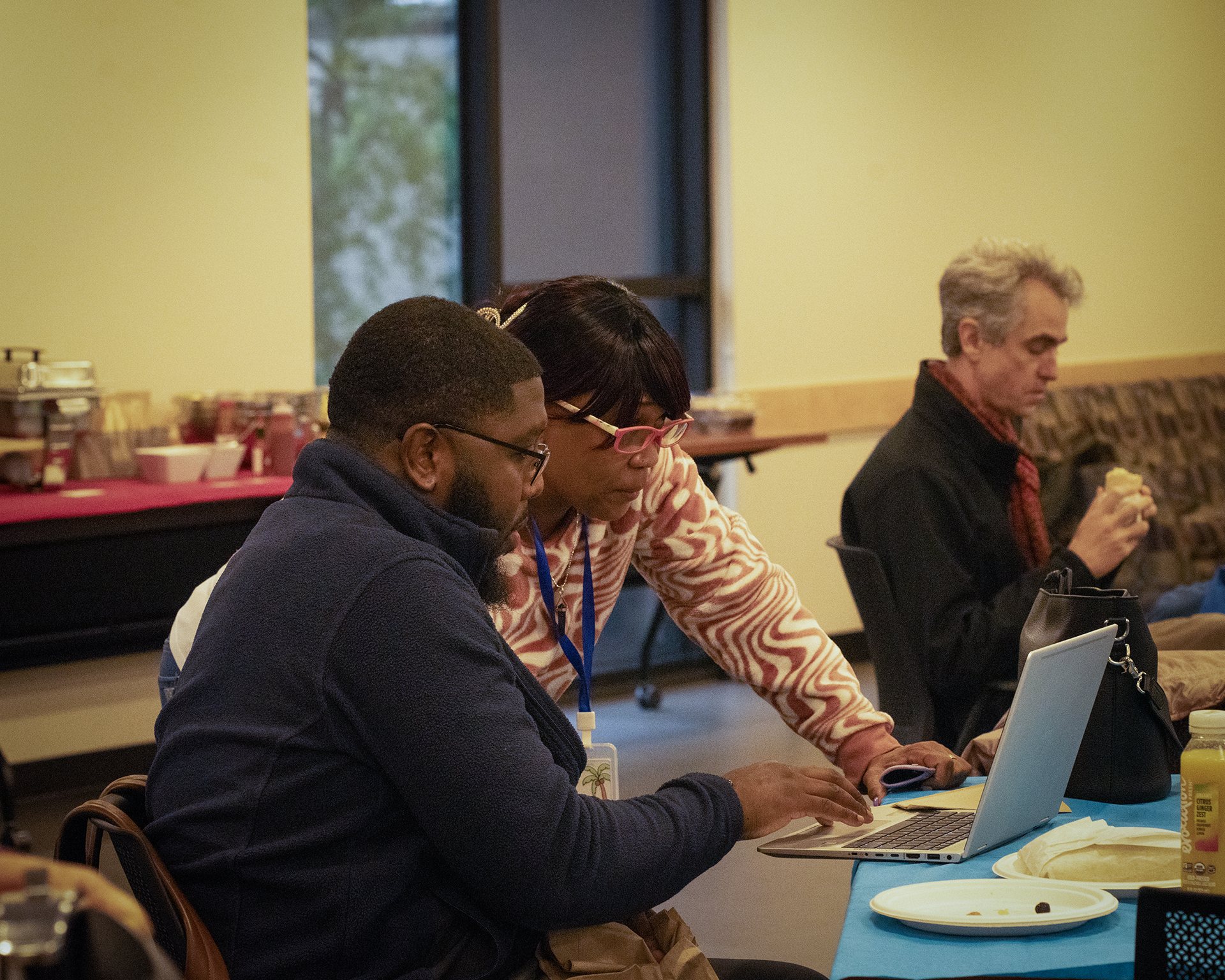 Two people look at a computer