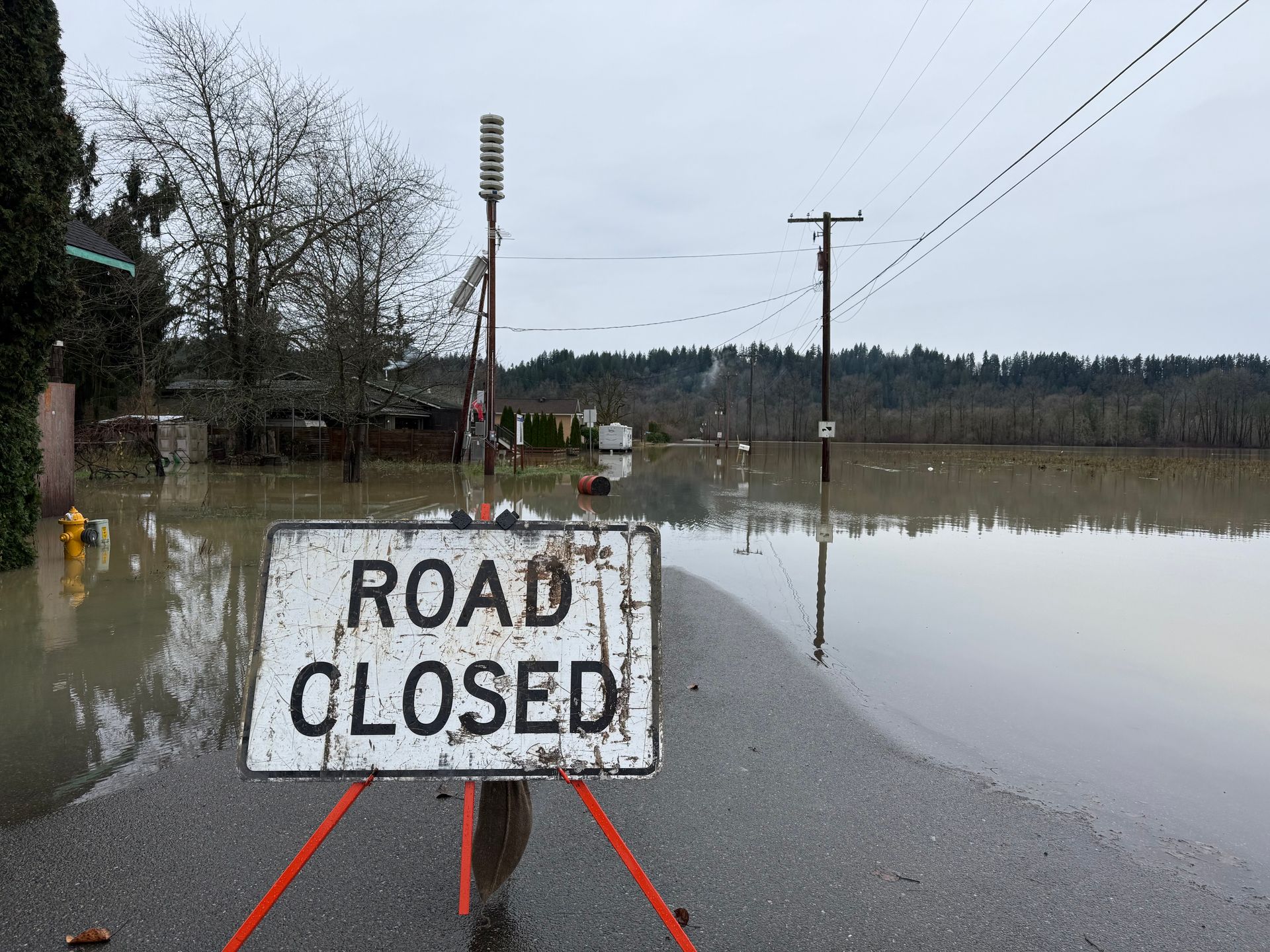 A road closed sign in front of a flooded street in Carnation.